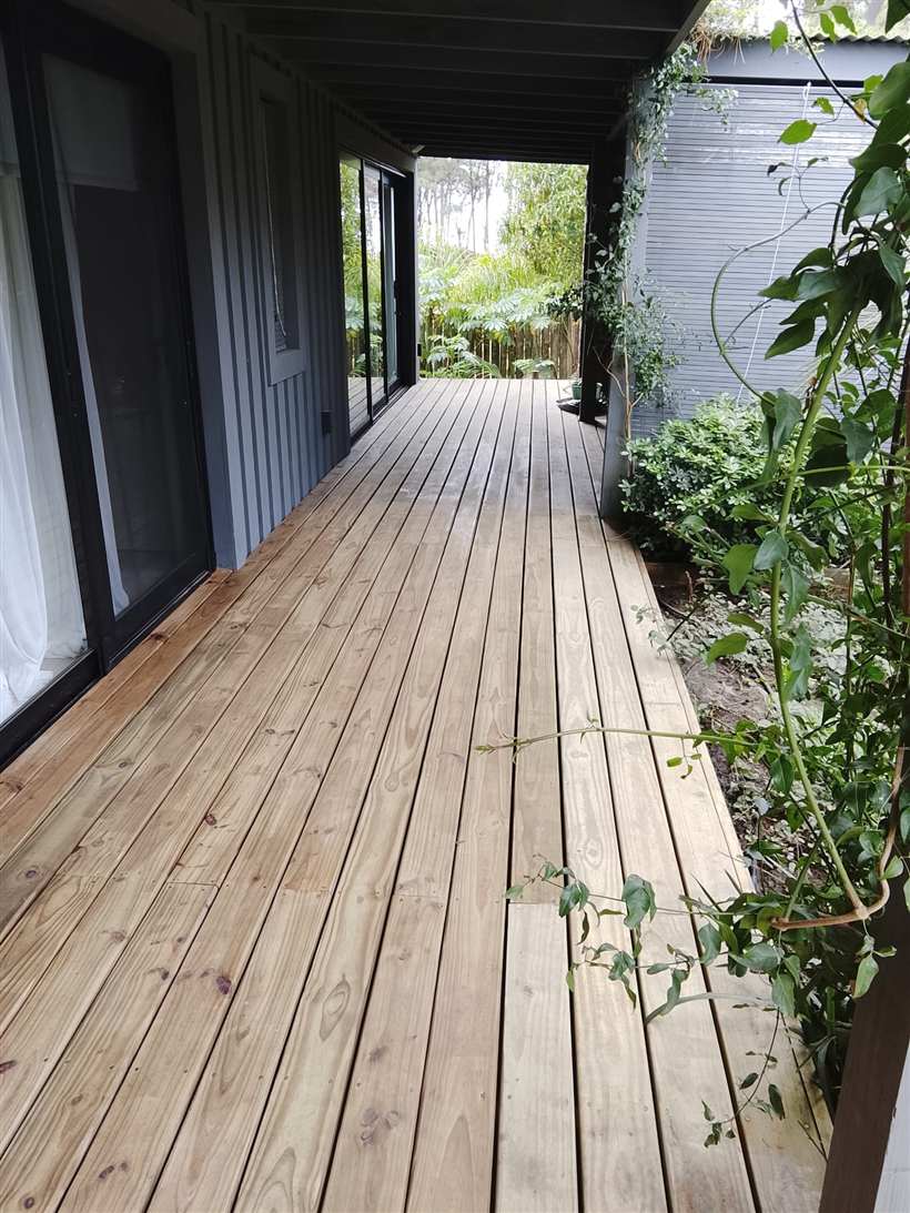 Deck de madera recién pintado a lo largo de la galería de la casa
