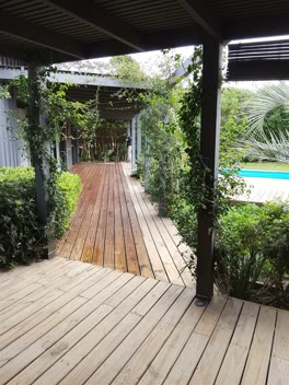 Deck de madera bajo una pérgola con jazmines