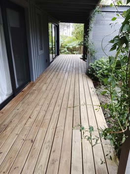 Deck de madera recién pintado a lo largo de la galería de una casa